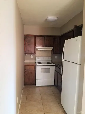 a kitchen with a refrigerator sink stove and cabinets