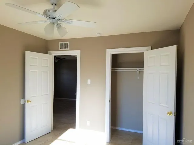a view of a hallway with a chandelier fan