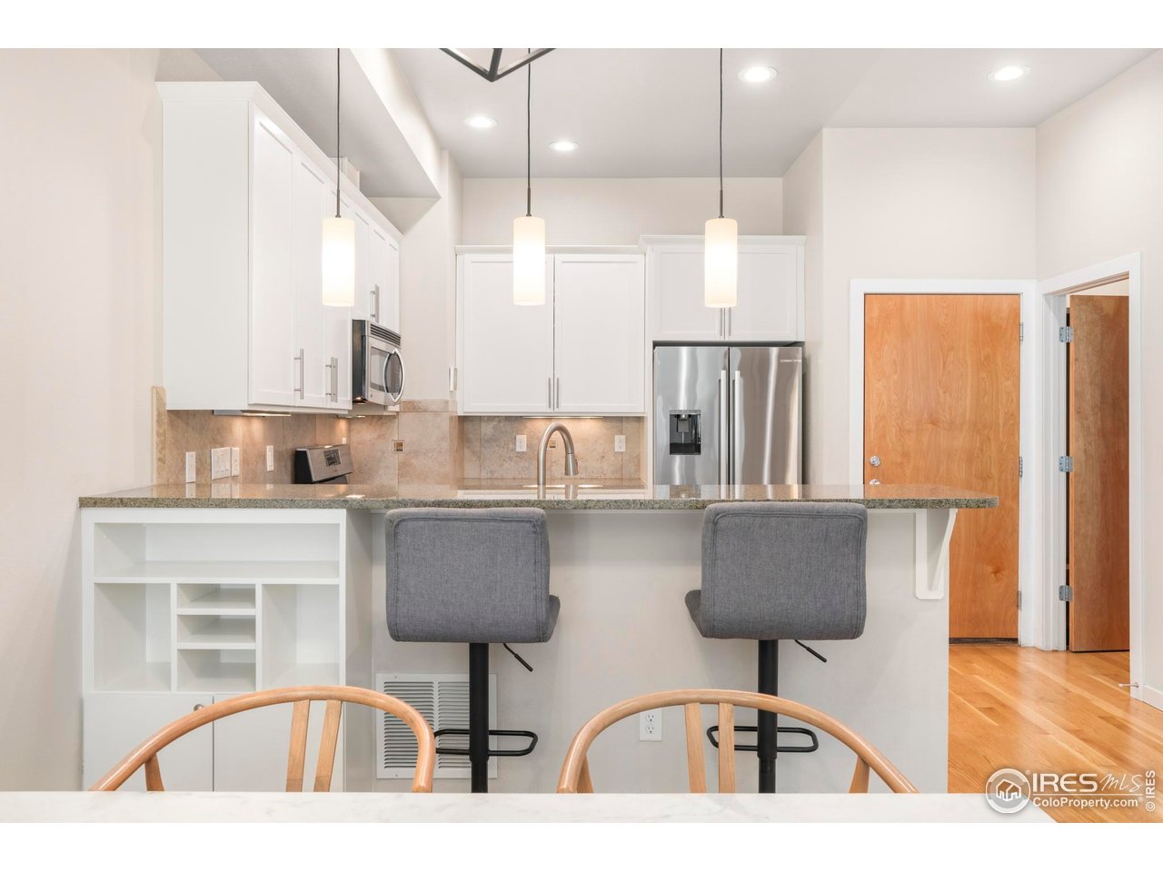 4190 Longview Lane Boulder, CO 80301 - Photo 8 of 29 a kitchen with stainless steel appliances kitchen island granite countertop a dining table chairs and a refrigerator
