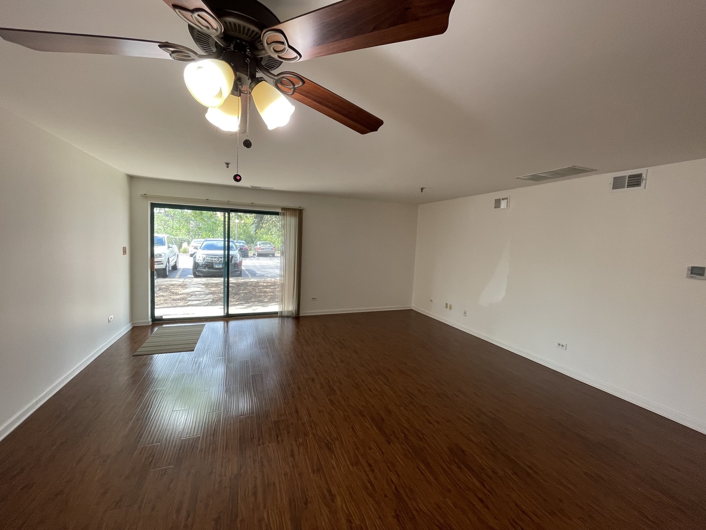 3265 Kirchoff Road, Unit 121 Rolling Meadows, IL 60008 - Photo 5 of 14 a view of an empty room with wooden floor and a window