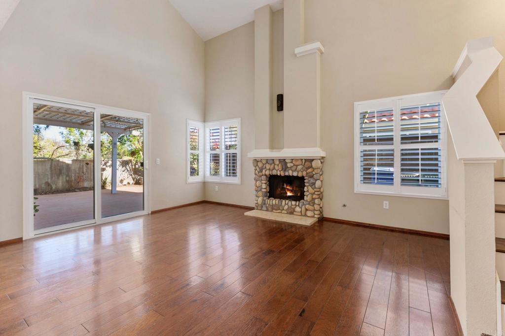 1521 Flair Encinitas Drive Encinitas, CA 92024 - Photo 9 of 45 an empty room with wooden floor fireplace and windows