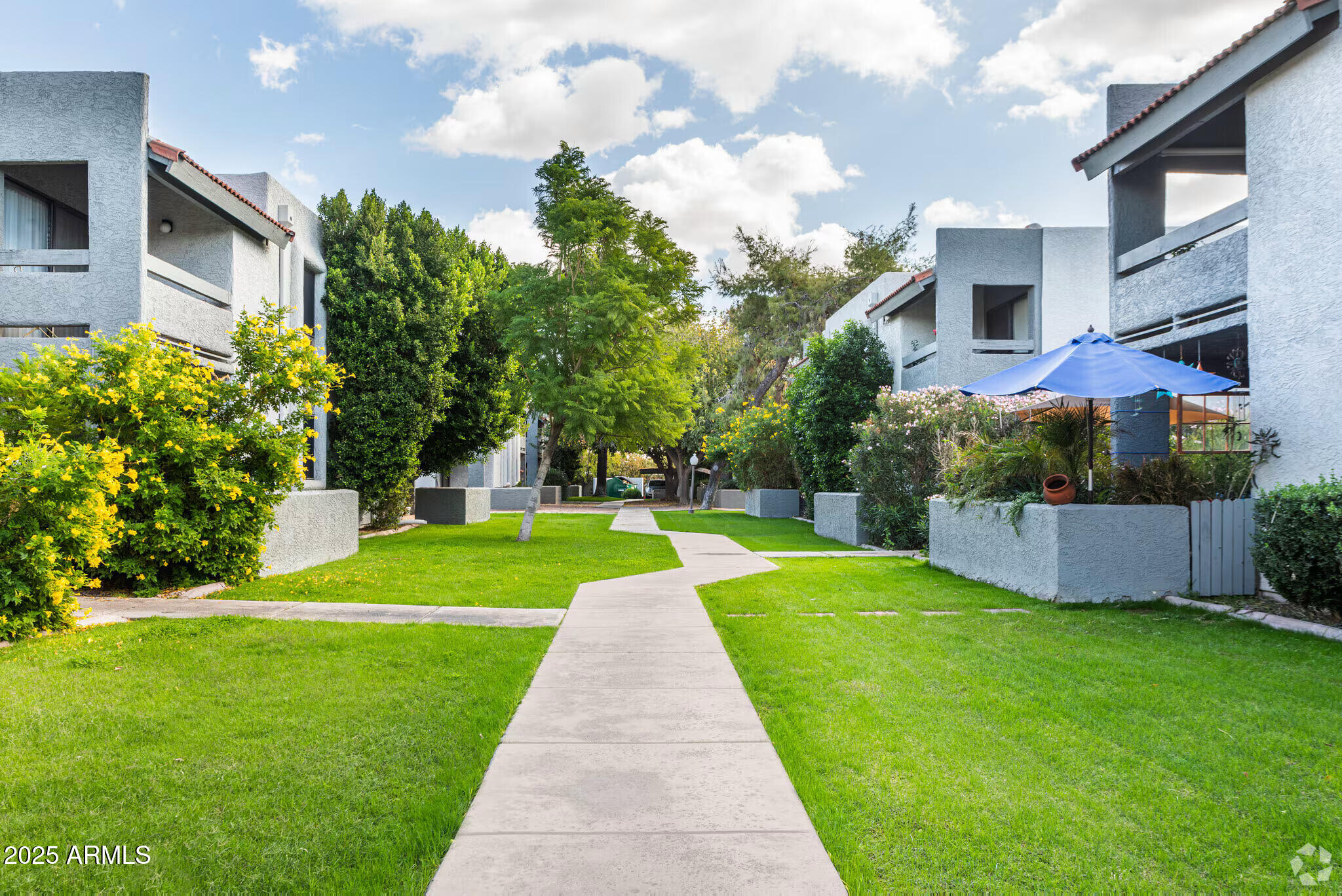 6505 East Osborn Road, Unit OFC Scottsdale, AZ 85251 - Photo 11 of 11 a view of a white house next to a yard with big trees