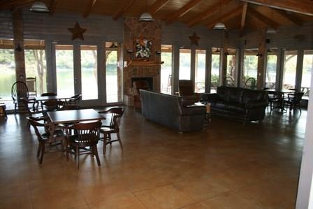 D69 Hensley Road Gordon, TX 76453 - Photo 18 of 34 a living room with furniture a fireplace and a dining table with wooden floor