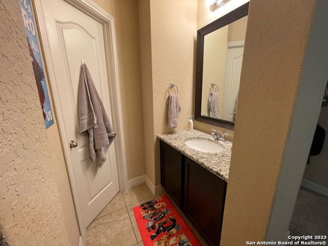 12310 Coal Mine Rise San Antonio, TX 78245 - Photo 15 of 19 a bathroom with a granite countertop sink and a mirror