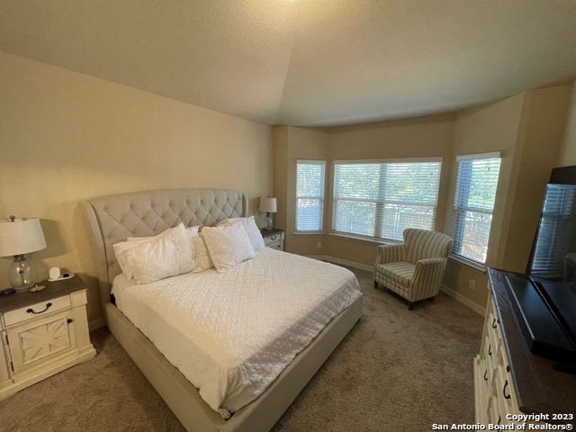 12310 Coal Mine Rise San Antonio, TX 78245 - Photo 5 of 19 a large bed sitting in a bedroom next to a window with lamp