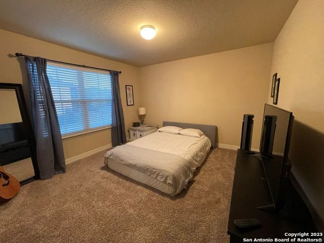 12310 Coal Mine Rise San Antonio, TX 78245 - Photo 9 of 19 a spacious bedroom with a bed and wooden floor