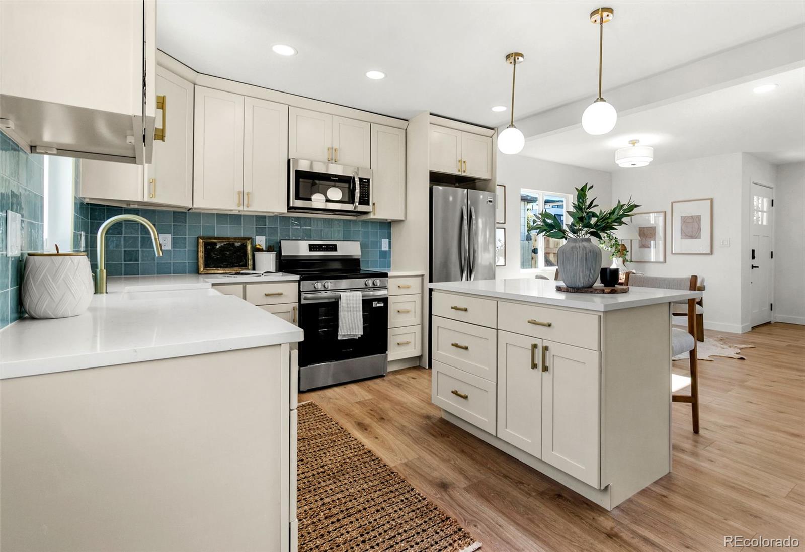 990 Tennyson Street Denver, CO 80204 - Photo 15 of 29 a kitchen with stainless steel appliances a stove refrigerator sink and cabinets