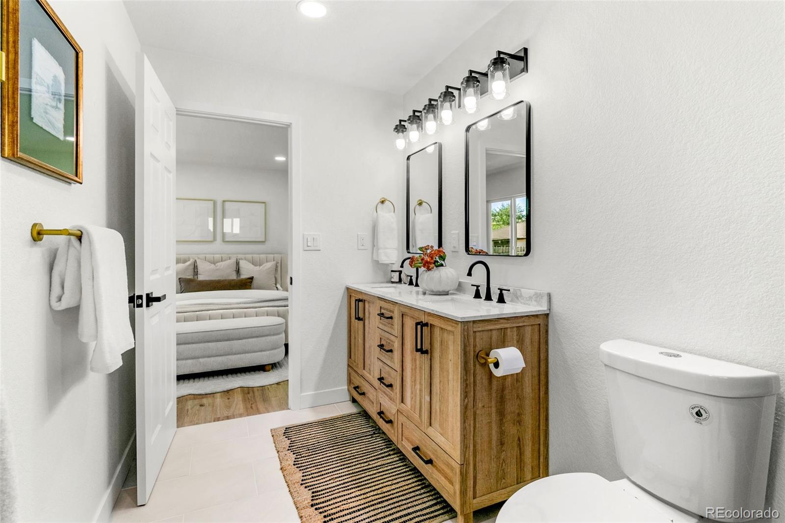 990 Tennyson Street Denver, CO 80204 - Photo 20 of 29 a bathroom with a sink a toilet and mirror