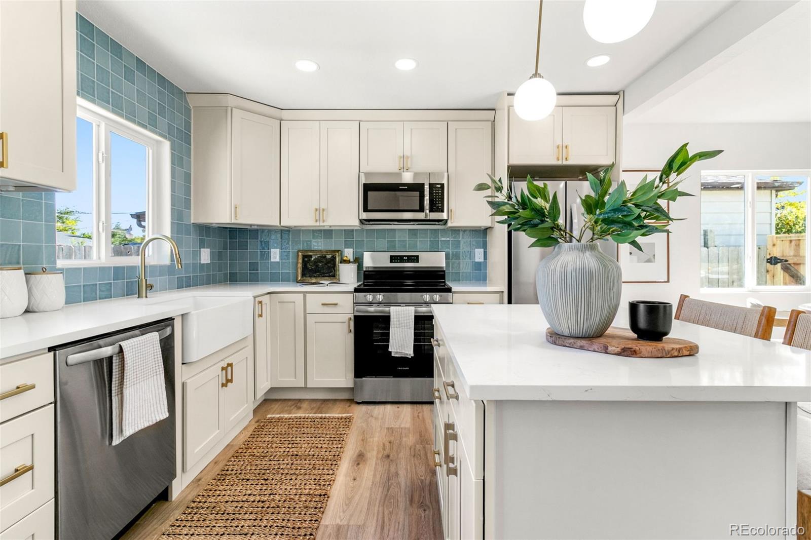 990 Tennyson Street Denver, CO 80204 - Photo 4 of 29 a kitchen with kitchen island white cabinets and stainless steel appliances
