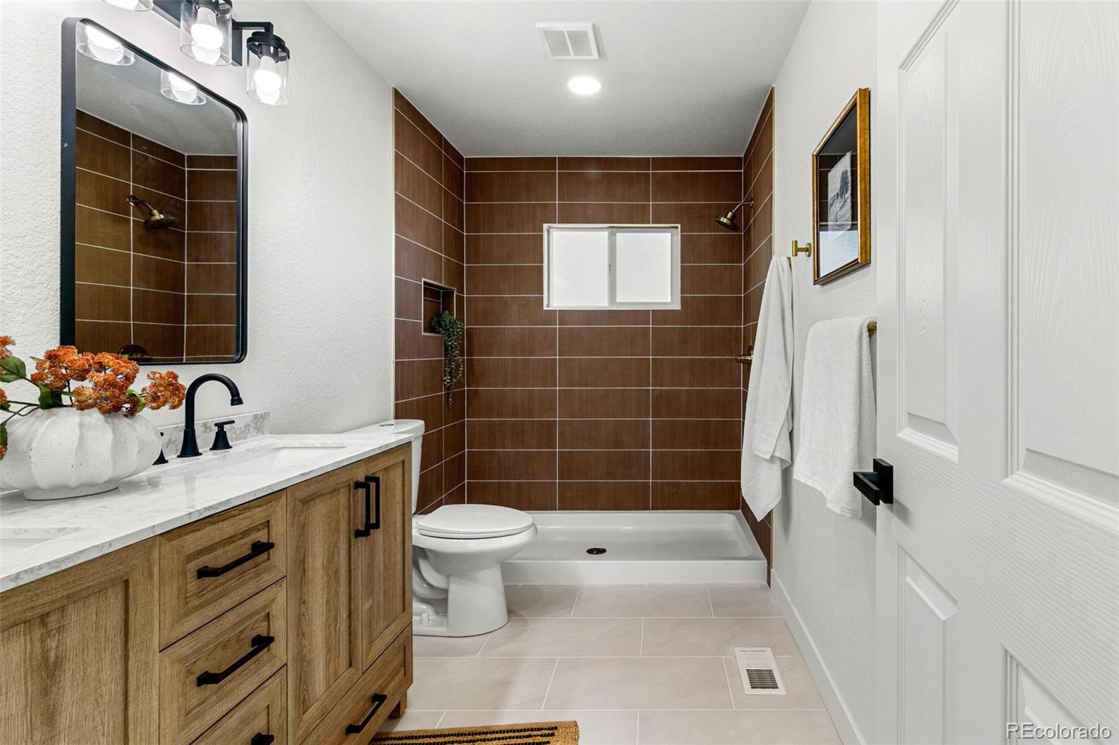 990 Tennyson Street Denver, CO 80204 - Photo 7 of 29 a bathroom with a sink a toilet a tub and shower