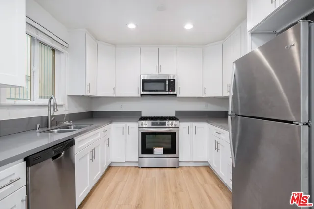 a kitchen with a refrigerator sink and stove