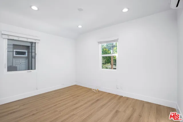an empty room with wooden floor and a window