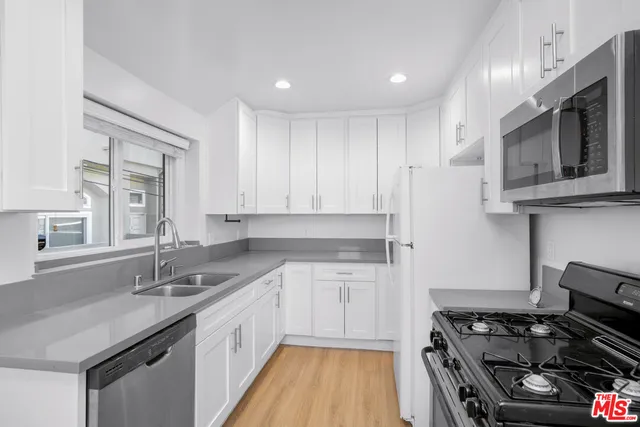 a kitchen with stainless steel appliances granite countertop a sink stove and cabinets