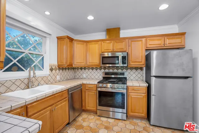 a kitchen with stainless steel appliances a stove a sink and a refrigerator