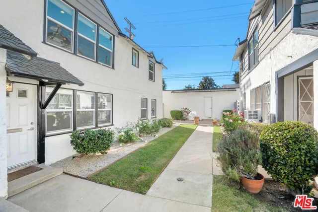a view of a white house next to a yard