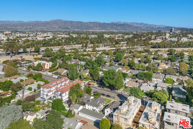 an aerial view of residential house with parking and trees
