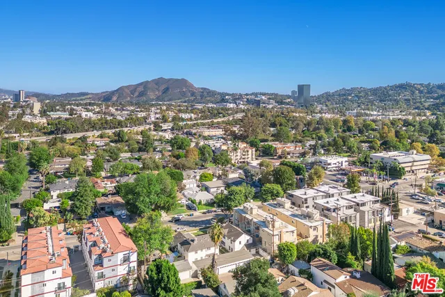 an aerial view of residential houses with city view
