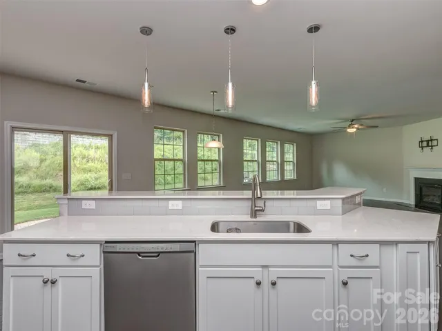 a kitchen with granite countertop a sink and white cabinets