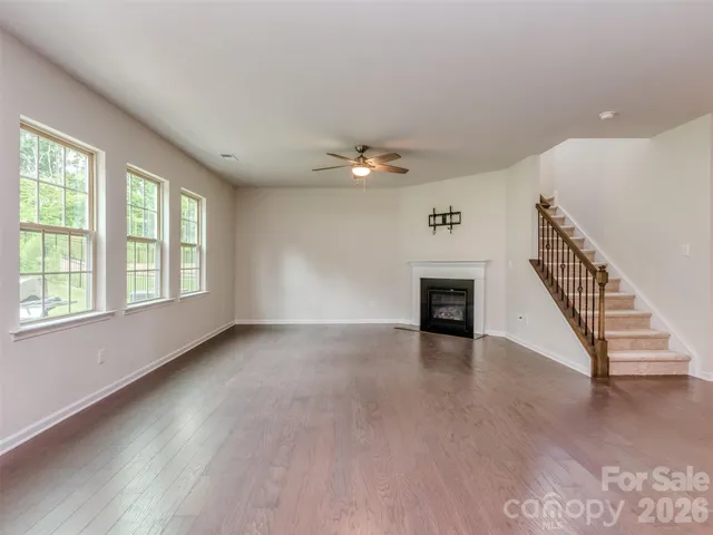 an empty room with windows and a ceiling fan