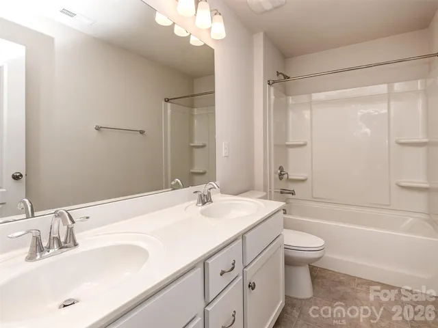 a bathroom with a bathtub shower sink vanity and toilet