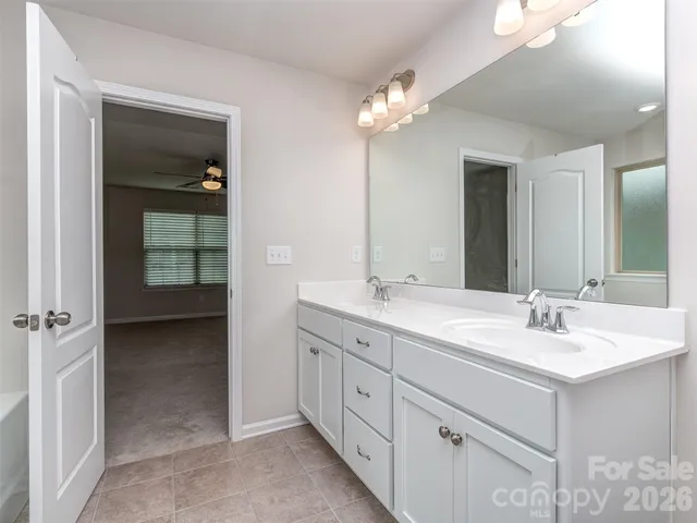 a spacious bathroom with a double vanity sink and a mirror