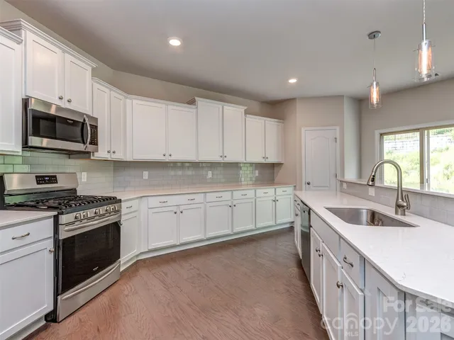 a kitchen with granite countertop a sink and a stove top oven