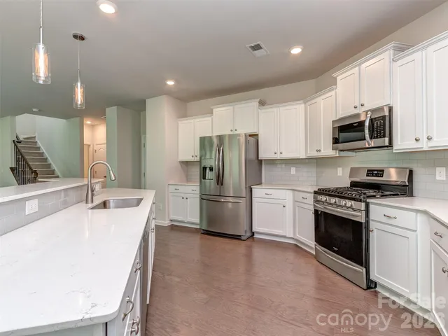 a kitchen with stainless steel appliances a refrigerator sink and microwave