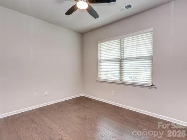an empty room with a window and a ceiling fan