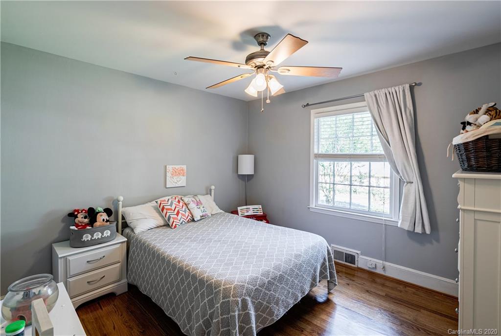 7026 Morganford Road Charlotte, NC 28211 - Photo 11 of 35 a bedroom with a bed and a chandelier