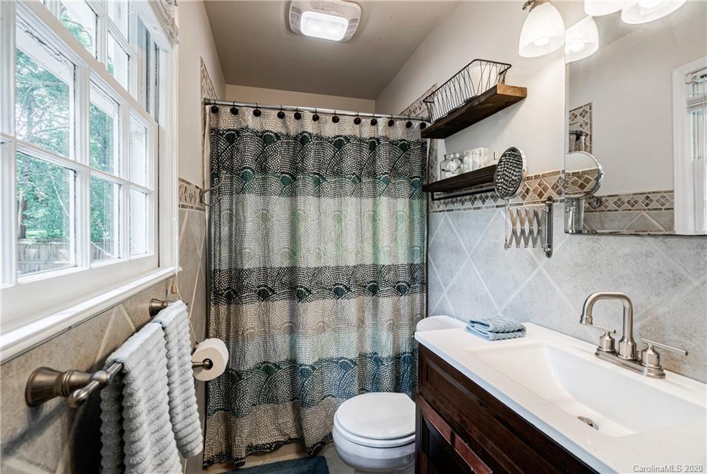7026 Morganford Road Charlotte, NC 28211 - Photo 16 of 35 a bathroom with a sink toilet a mirror and shower