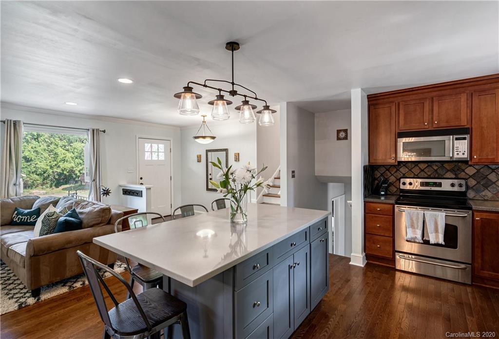 7026 Morganford Road Charlotte, NC 28211 - Photo 4 of 35 a kitchen with a table chairs stainless steel appliances and wooden floor