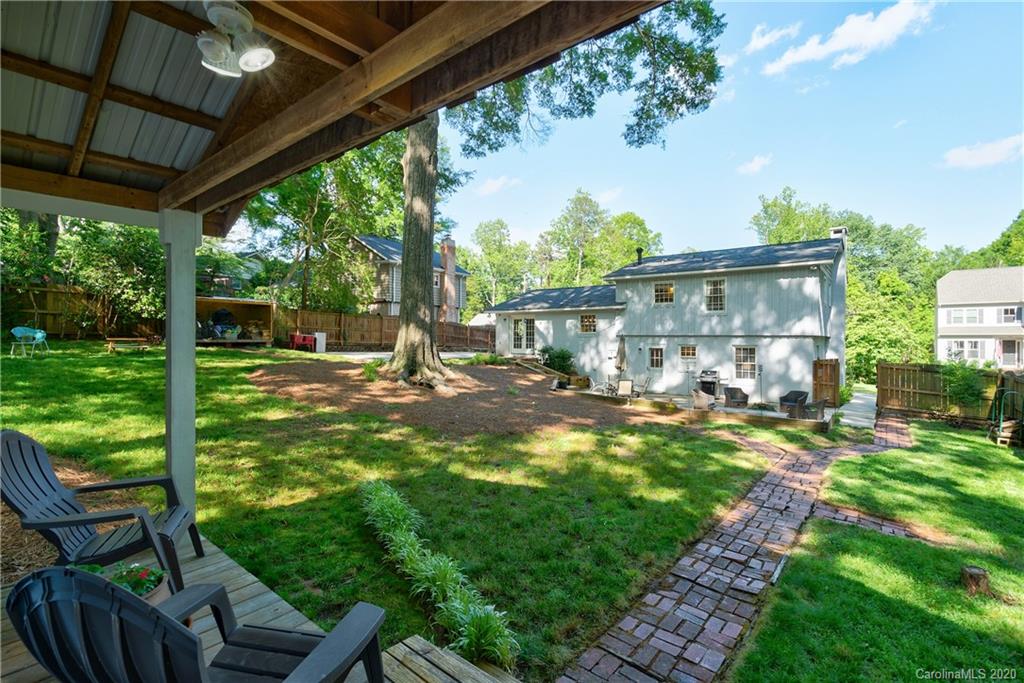 7026 Morganford Road Charlotte, NC 28211 - Photo 31 of 35 a view of a patio with table and chairs under an umbrella with a big yard