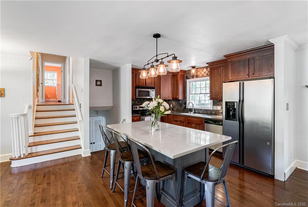 7026 Morganford Road Charlotte, NC 28211 - Photo 5 of 35 a kitchen with stainless steel appliances a dining table chairs and wooden floor
