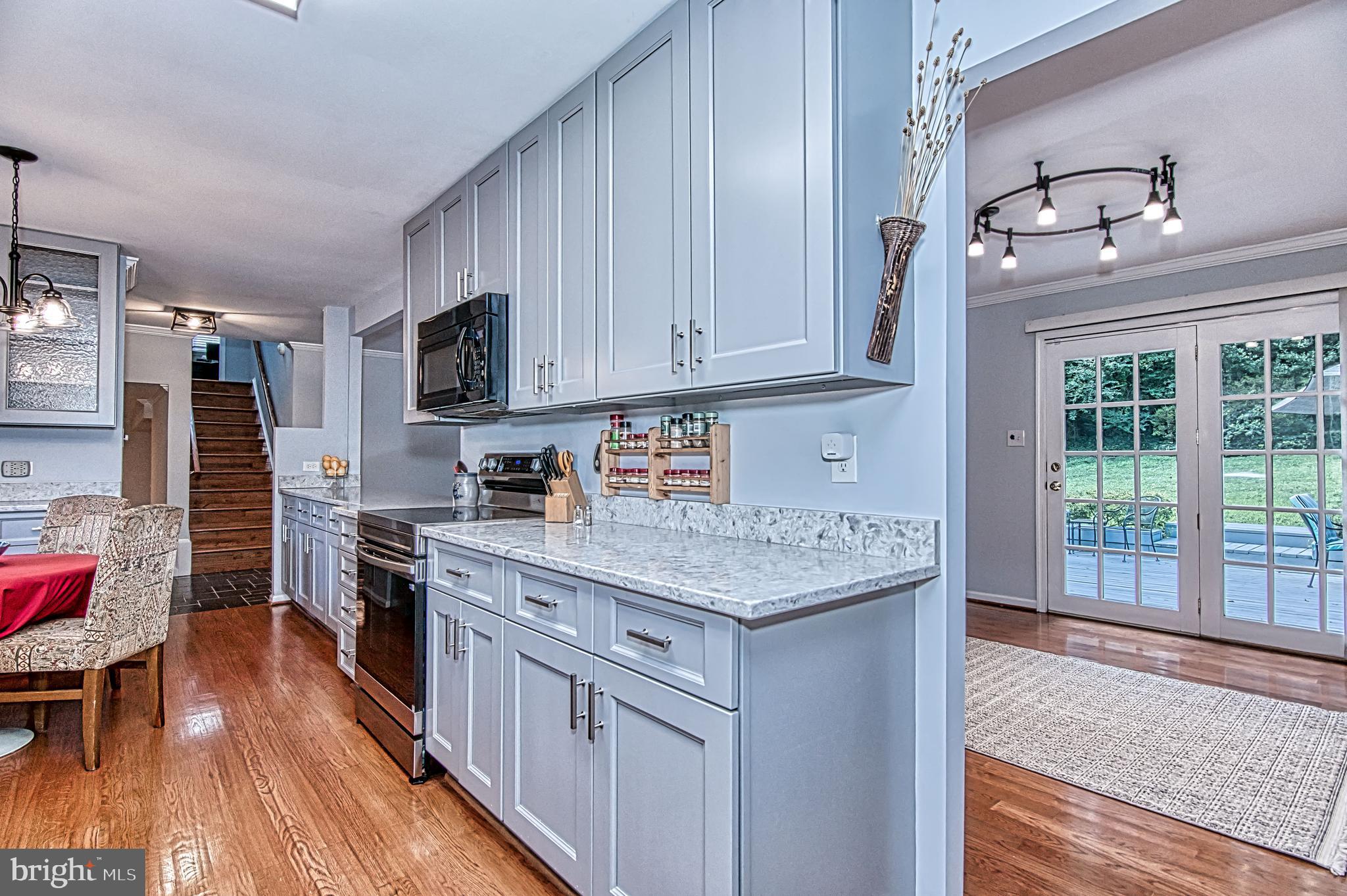 7128 Devonshire Road Alexandria, VA 22307 - Photo 13 of 36 a kitchen with stainless steel appliances granite countertop a stove a sink dishwasher and a refrigerator with wooden floor