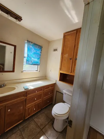 a bathroom with a toilet a sink and a mirror