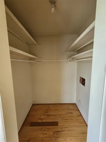 a view of a room with wooden floor and white walls