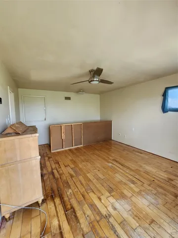 a view of a kitchen with furniture and wooden floor