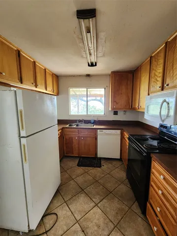 a kitchen with a refrigerator sink and cabinets