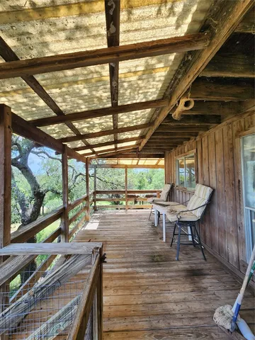 a view of a porch with furniture and a backyard