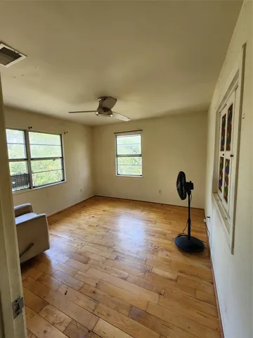 wooden floor in an empty room with a window