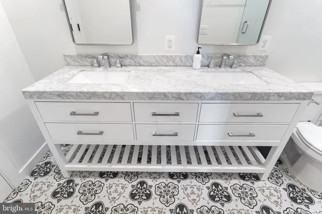 a bathroom with a granite countertop sink and a mirror