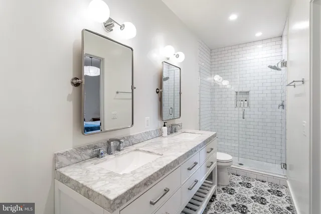 a bathroom with a granite countertop sink a toilet and shower