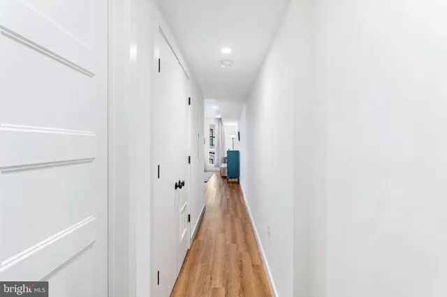 a view of a hallway with wooden floor and staircase