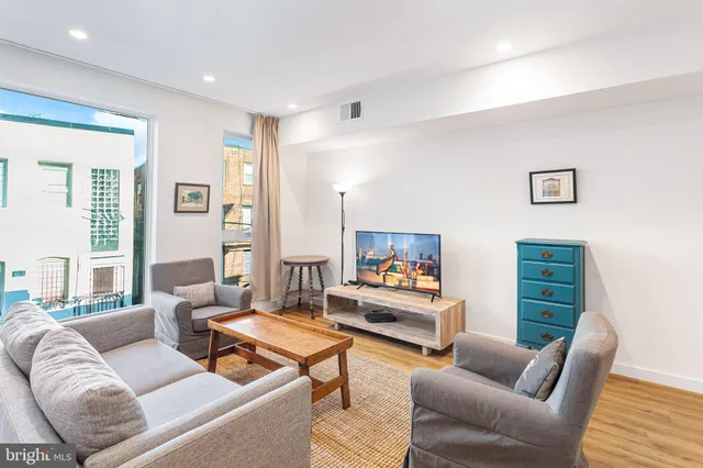 a living room with furniture a rug and a window