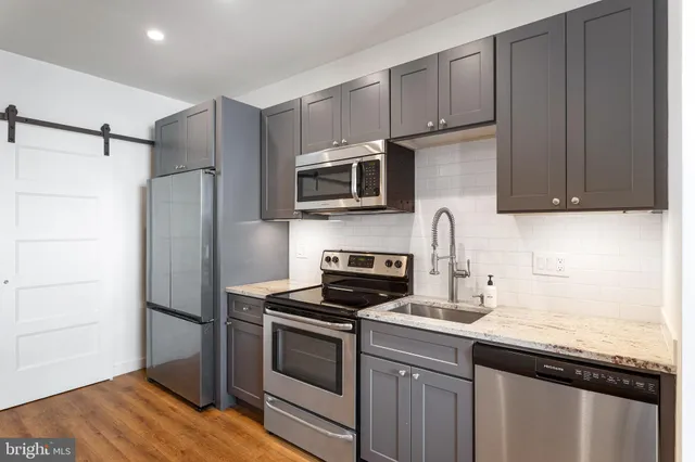 a kitchen with stainless steel appliances granite countertop a stove microwave and refrigerator