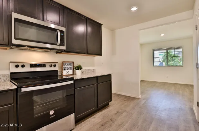 a kitchen with stainless steel appliances a stove microwave and sink