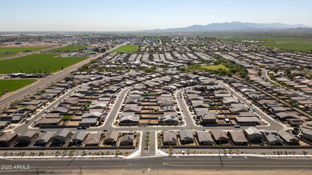 an aerial view of ocean and residential houses with outdoor space