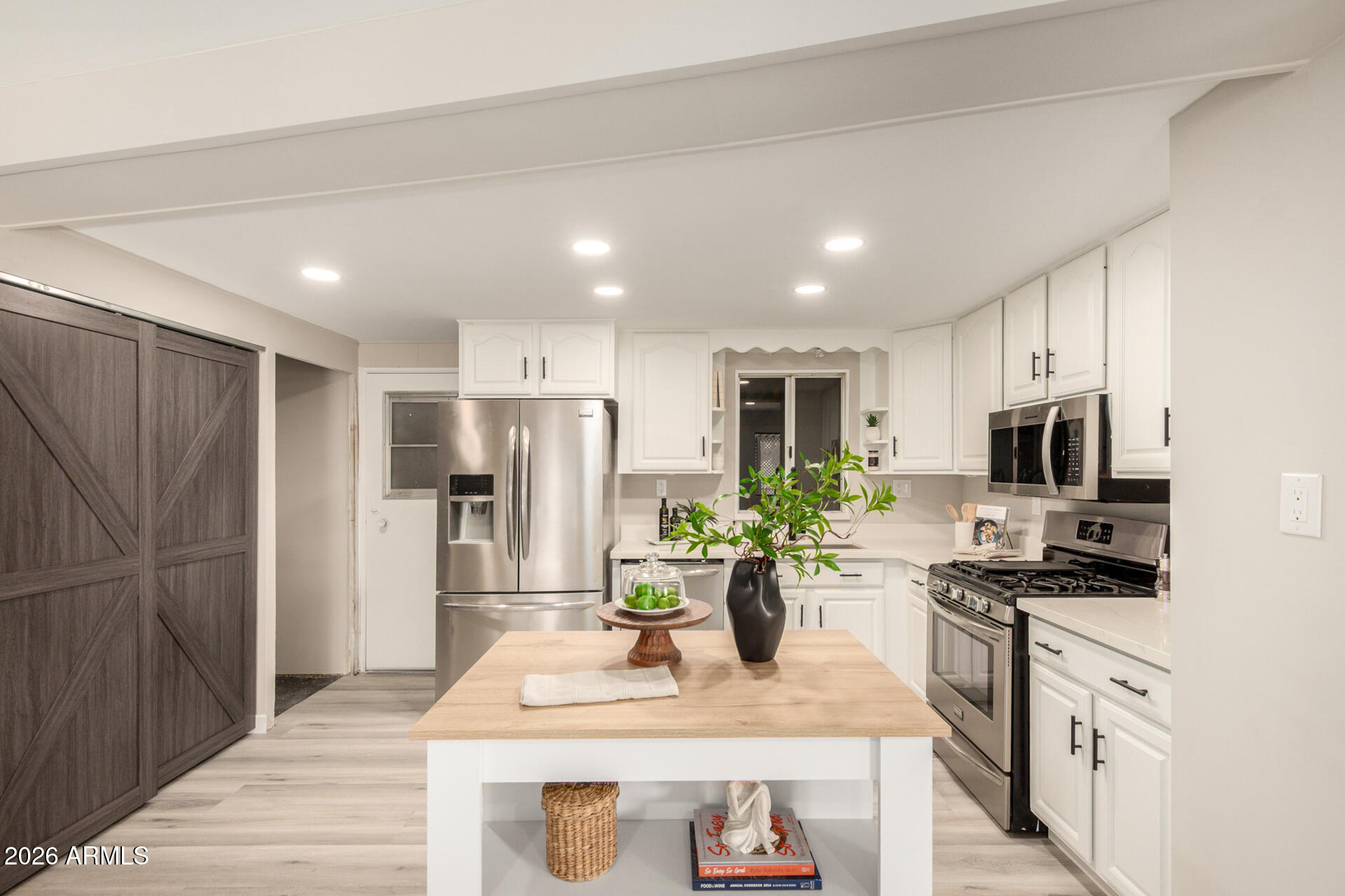 422 South 80th Way Mesa, AZ 85208 - Photo 14 of 28 a kitchen with stainless steel appliances granite countertop a refrigerator a stove a sink dishwasher a microwave oven with cabinets and wooden floor