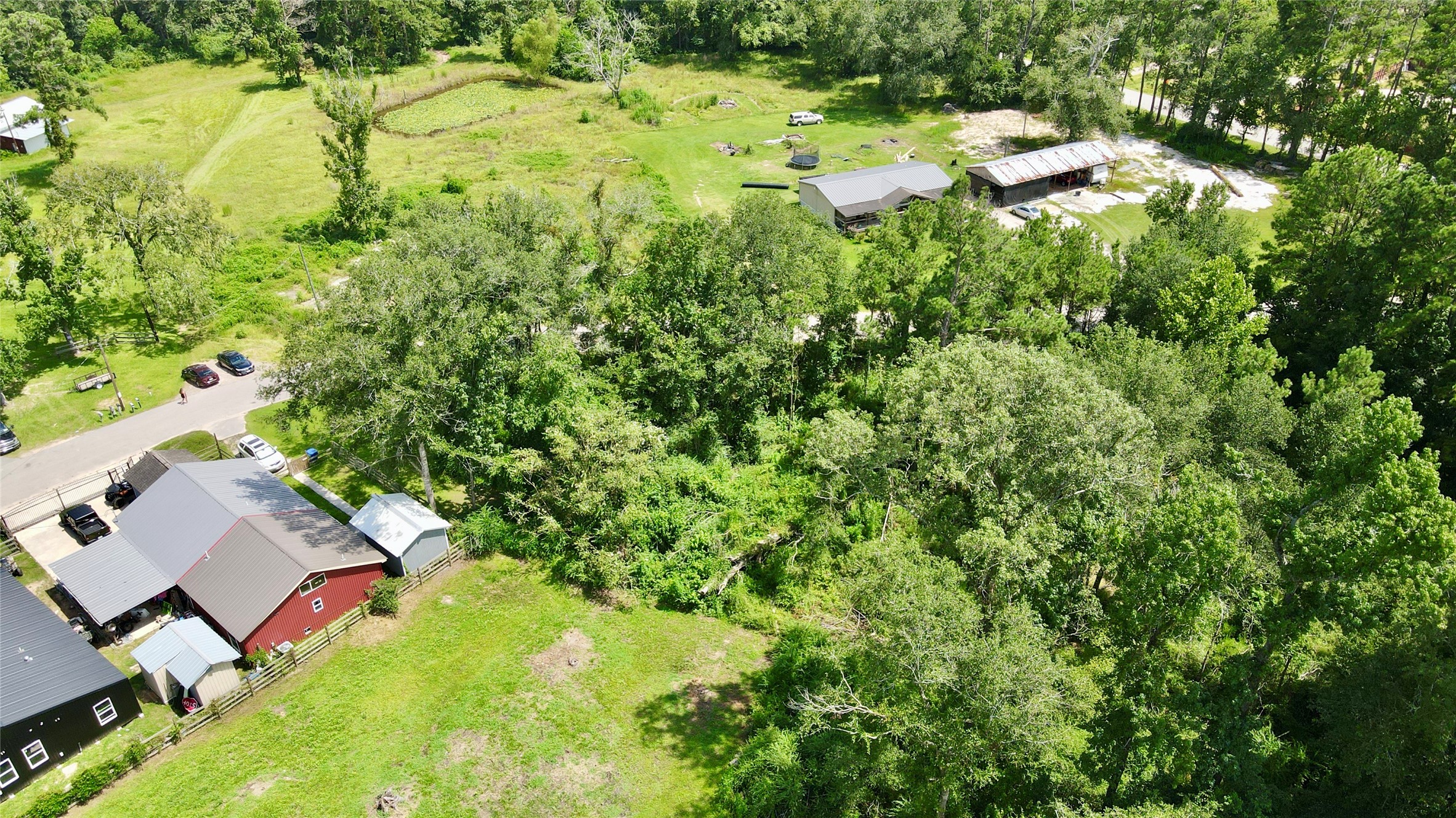 17138 Hl Patton Boulevard Splendora, TX 77372 - Photo 6 of 8 a backyard of a house with a yard and large tree