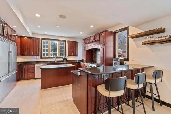 a kitchen with stainless steel appliances kitchen island granite countertop a sink and cabinets